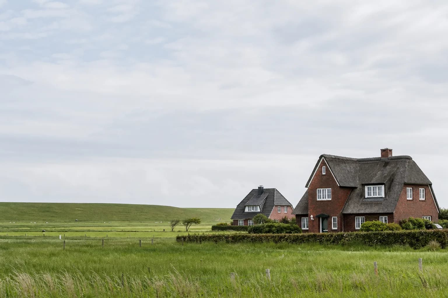 Backsteinhäuser in flacher Küstenlandschaft in Schleswig-Holstein